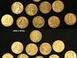 a close up of a bunch of gold coins on a black surface