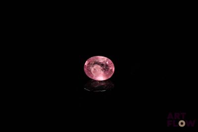 gros plan d'un diamant rose sur une surface noire