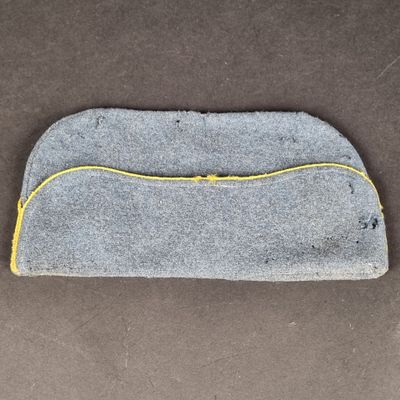un gros plan d'un sac gris et jaune posé sur une surface marron
