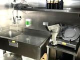 une cuisine en inox équipée d'un évier et d'un plan de travail