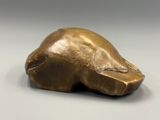 un gros plan sur une sculpture en bronze représentant une tête de chien