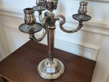 un candélabre en argent posé sur une petite table dans une pièce
