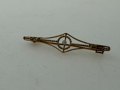 a picture of a gold hair clip on a white surface
