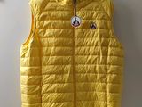 the yellow vest is hanging on the wall by a hanger