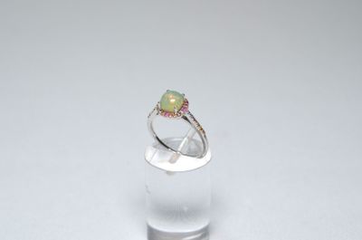 a close up of a ring with a green oplite in it