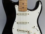 a close up of a black electric guitar on a white background