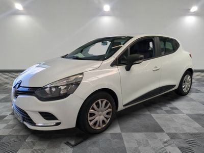 une voiture blanche est garée dans une pièce au sol à carreaux