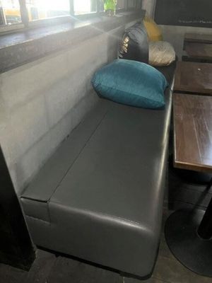 un banc sur lequel est posé un coussin, à côté d'une table