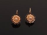 a pair of gold earrings with a flower design