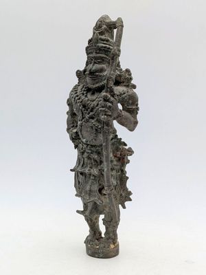 une vieille statue représentant un homme armé d'une épée, sur fond blanc