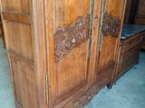 a wooden armoire with carvings on it in a room