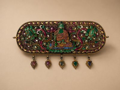 un gros plan d'une broche ornée de perles, accrochée à un mur