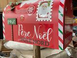 a mailbox with a christmas message on it sitting on top of a pile of bags