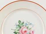 a white plate with a pink flower on it