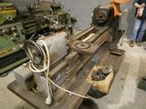 un homme debout à côté d'une machine dans un atelier