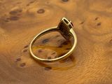 a close up of a gold ring on a wooden surface