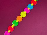 a close up of a colorful bracelet on a purple background