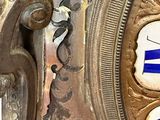 a silver clock with blue and white designs on it