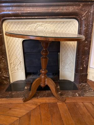 une petite table avec un plateau en verre devant une cheminée