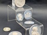 une pile de pièces et une pièce sur laquelle figure le portrait d'un homme