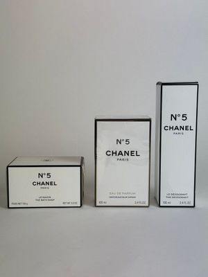 three boxes of perfume sitting next to each other on a white surface