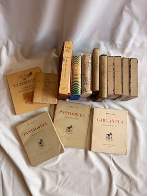 Plusieurs livres sont posés sur un lit recouvert d'un drap blanc.