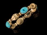 un gros plan d'un bracelet en or orné de pierres de turquoise