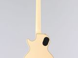 a white guitar hanging from a string on a gray background