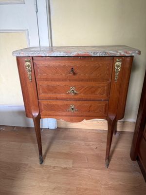 a small marble top cabinet in the corner of a room