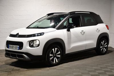 la citrole blanche est garee dans un garage au sol en damier