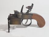 a small toy gun with a wooden handle on a white surface