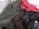 a pile of clothes that is sitting on a bed