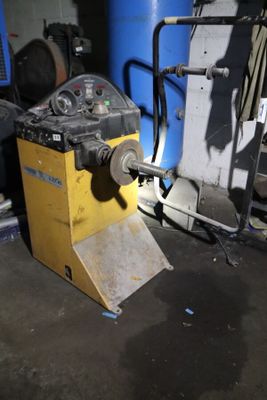 une machine qui se trouve dans une pièce, à côté d'un tonneau bleu
