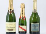 trois bouteilles de champagne posées les unes à côté des autres sur une surface blanche