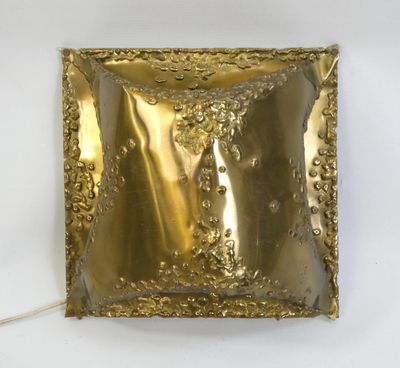 brass plate with a decorative design on it on a white surface