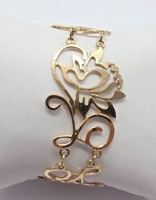 un gros plan d'un bracelet en or orné d'une fleur