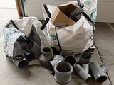 a pile of duct fittings on the ground next to a garage door