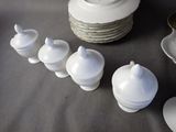 a lot of white dishes and cups on a table
