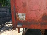 a rusted red dump truck parked on the side of the road