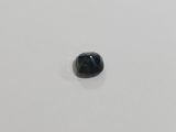 a close up of a black diamond on a white surface