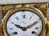 a white and gold clock sitting on top of a table