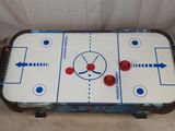 an image of a table top air hockey game with red and blue balls on it