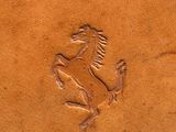 brown leather case with a horse carved into the side of it