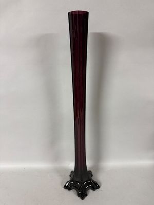 purple glass vase with a black base on a white background
