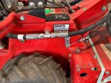 a close up of a red tractor with a large tire
