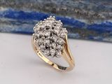 un gros plan d'une bague sertie de diamants en grappe posée sur une table