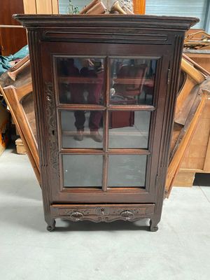 a wooden cabinet with a glass door on top of it