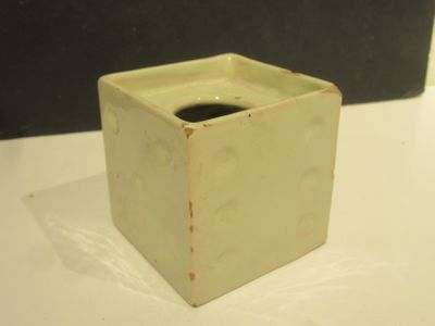 a small square vase with a hole in the middle