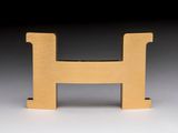 a close up of a wooden letter h on a white surface