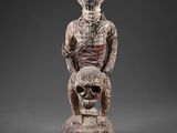 une statue en bois représentant un squelette et un personnage humain